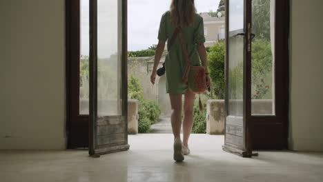 una joven fotógrafa está entrando en el jardín de la certosa de san giacomo en capri