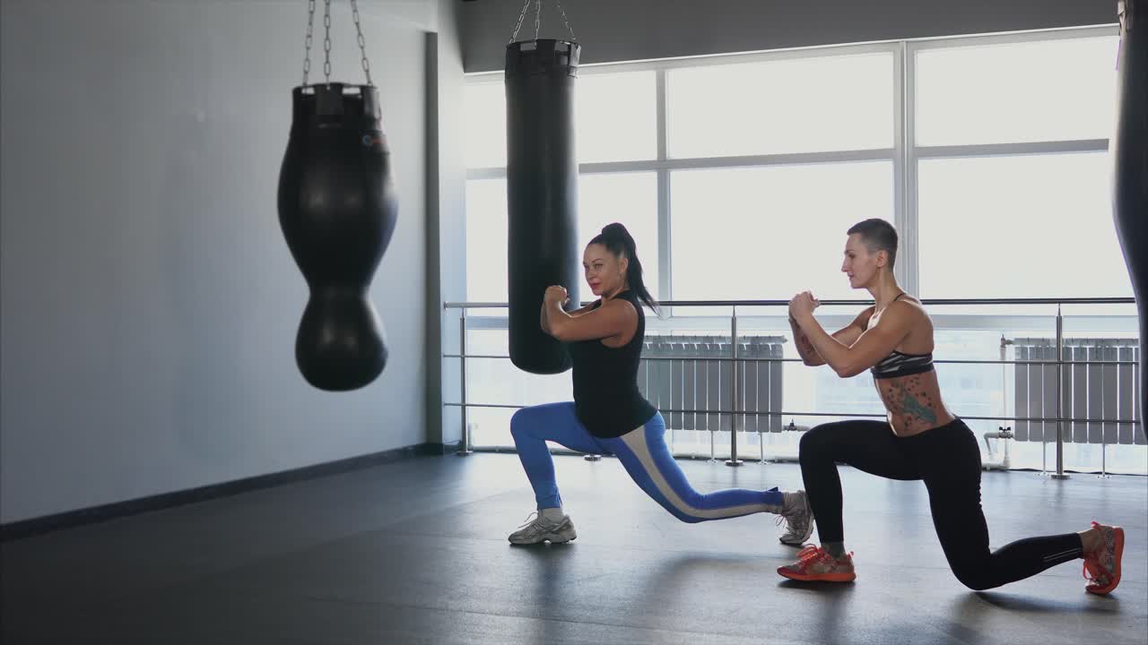 Women working out in a gym with boxing bags