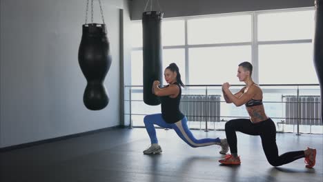 women working out in a gym with boxing bags