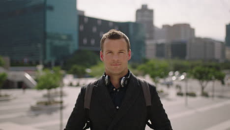 portrait of attractive young confident businessman smiling at camera successful executive relaxed in sunny urban city background