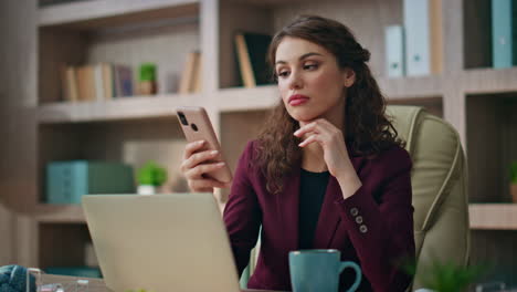 bored employee using smartphone at workplace. closeup executive looking mobile