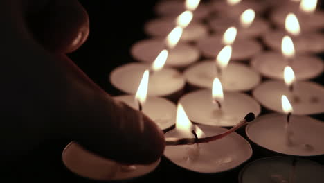 encendiendo a mano velas de luz de té con fósforos