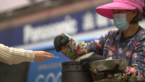 lady taking payment for hong kong street food