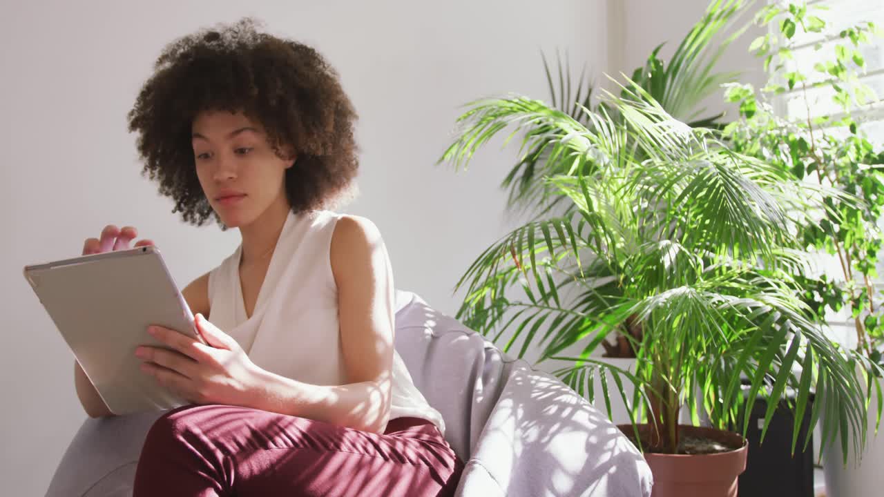 mujer de raza mixta usando tableta digital en la oficina creativa