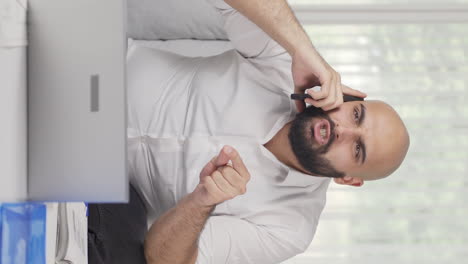 vertical video of home office worker man phone angry performs business call.