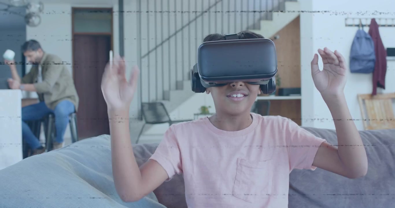 Bambino che indossa un visore VR esplorando un mondo VR e gesticolando mentre un genitore usa lo smartphone all'isola della cucina.
