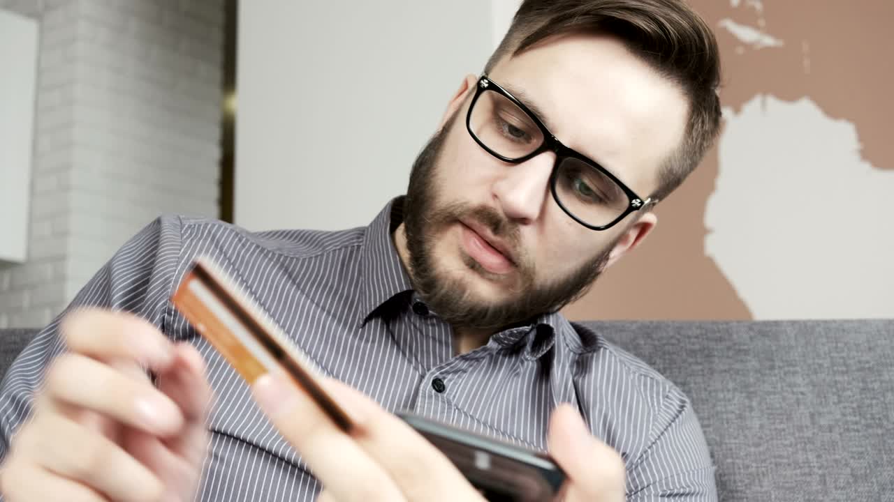 Uomo che paga online con carta bancaria tramite smartphone