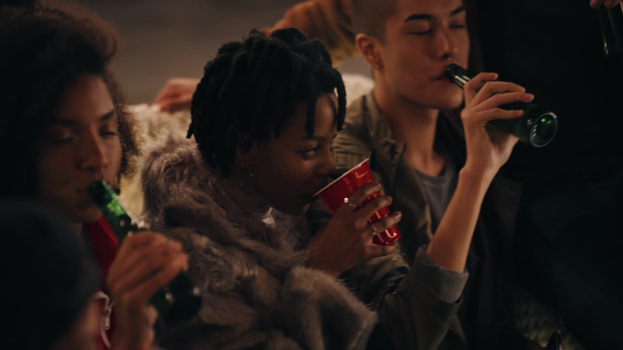 다민족 친구 그룹이 지붕 파티를 축하하고 토스트를 만들고 술을 마시고 주말에 재결합 축제를 즐기고 밤에 사회적 모임을 갖습니다.