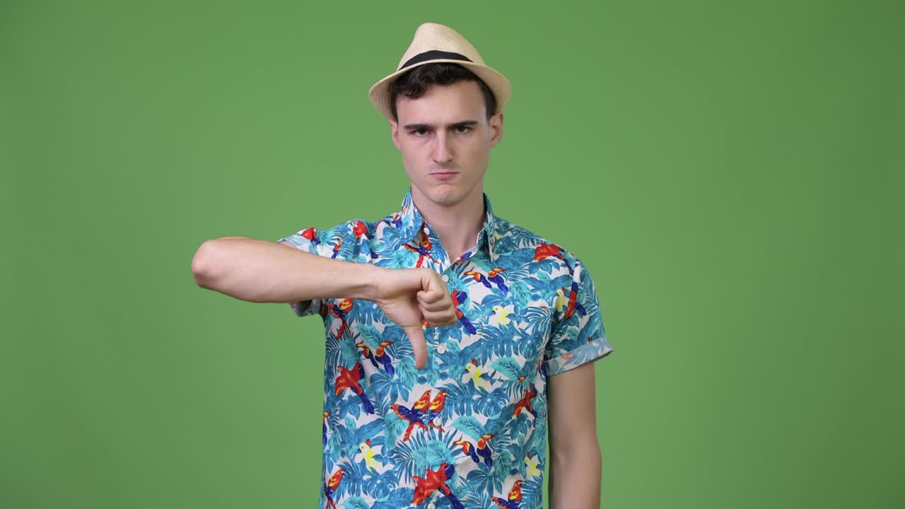 젊은 잘생긴 관광객이 엄지손가락을 내려놓고