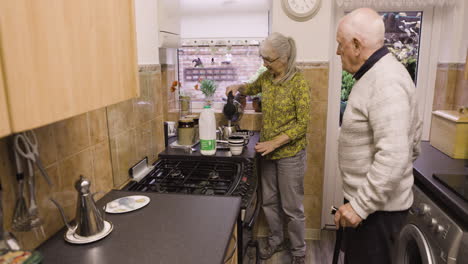 elderly couple making tea in the kitchen