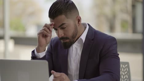 hombre de negocios serio trabajando con computadora portátil al aire libre