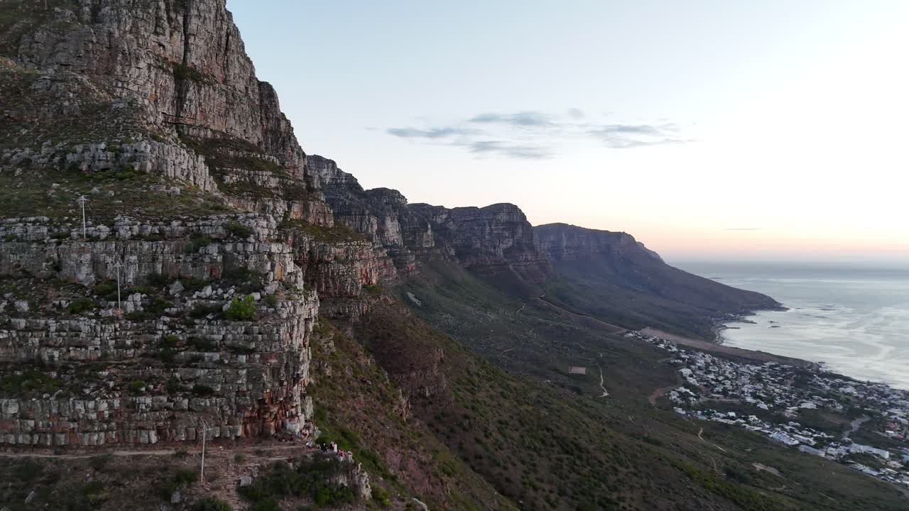 Drone view of Cape Town with Table Mountain at sunset, capturing colorful skies, iconic cliffs, and sweeping views of the Atlantic coastline
