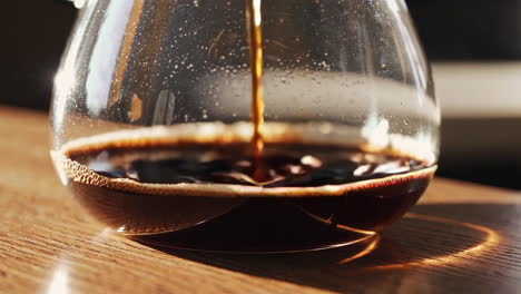 vertiendo café en una olla de vidrio