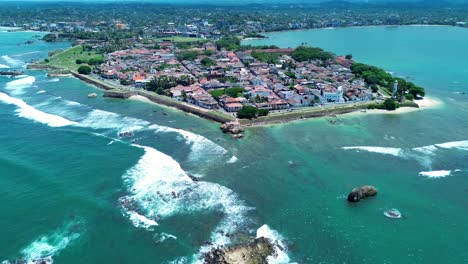 Aerial-drone-landscape-view-of-Galle-Old-town-square-Dutch-fort-history-architecture-surrounded-by-beach-ocean-lighthouse-Sri-Lanka-Asia