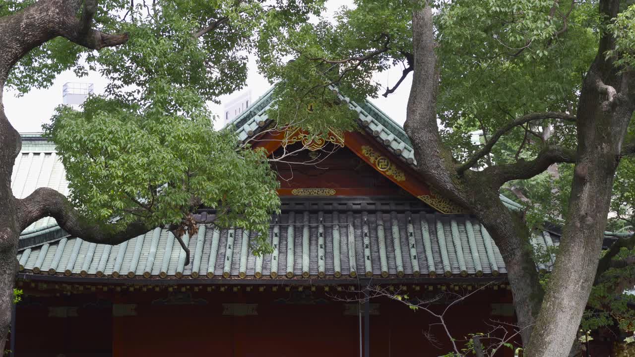 hermoso templo japonés flanqueado por árboles verdes que soplan con viento fuerte