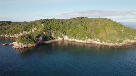 lush green island peninsula with coastal cliffs and cave