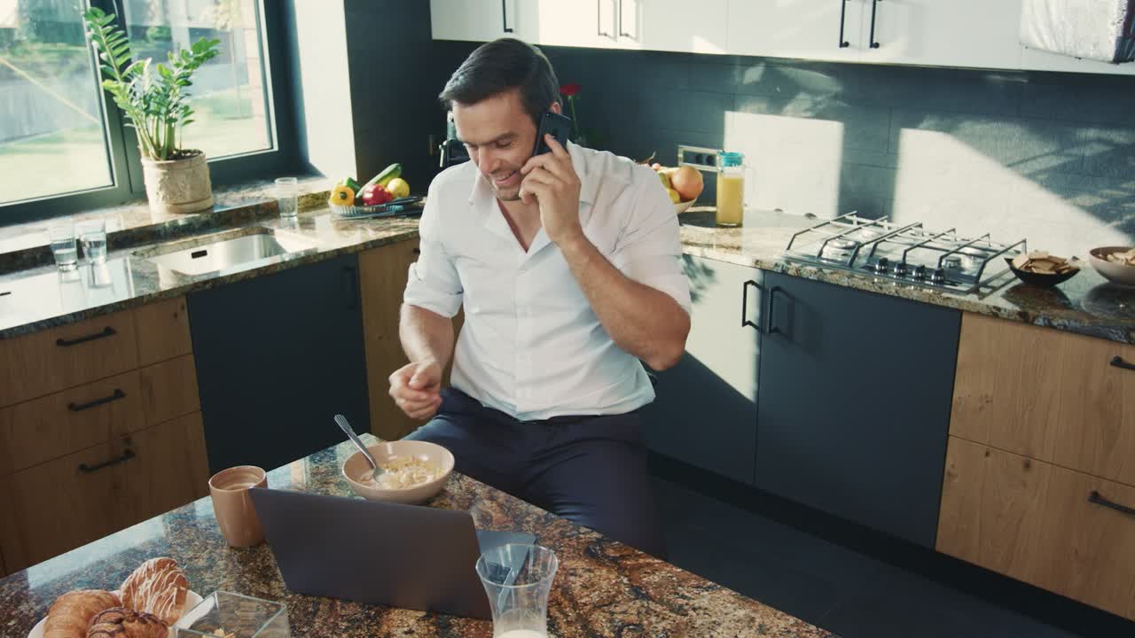 hombre feliz hablando por teléfono en la cocina. hombre relajado hablando por móvil.