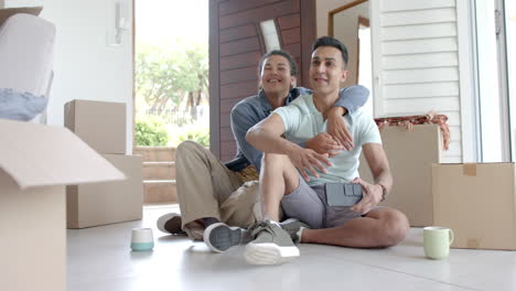 una pareja gay feliz y diversa se muda a una nueva casa tomando selfies, copiando espacio, cámara lenta