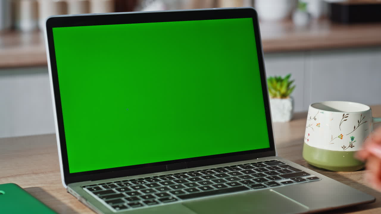 Woman finger pressing green screen laptop kitchen closeup. Lady touching button