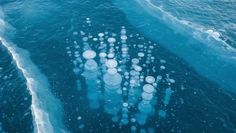 mesmerizing bubbles beneath the ice: a stunning aerial view of submerged bubbles captured in the calm waters of an icy landscape