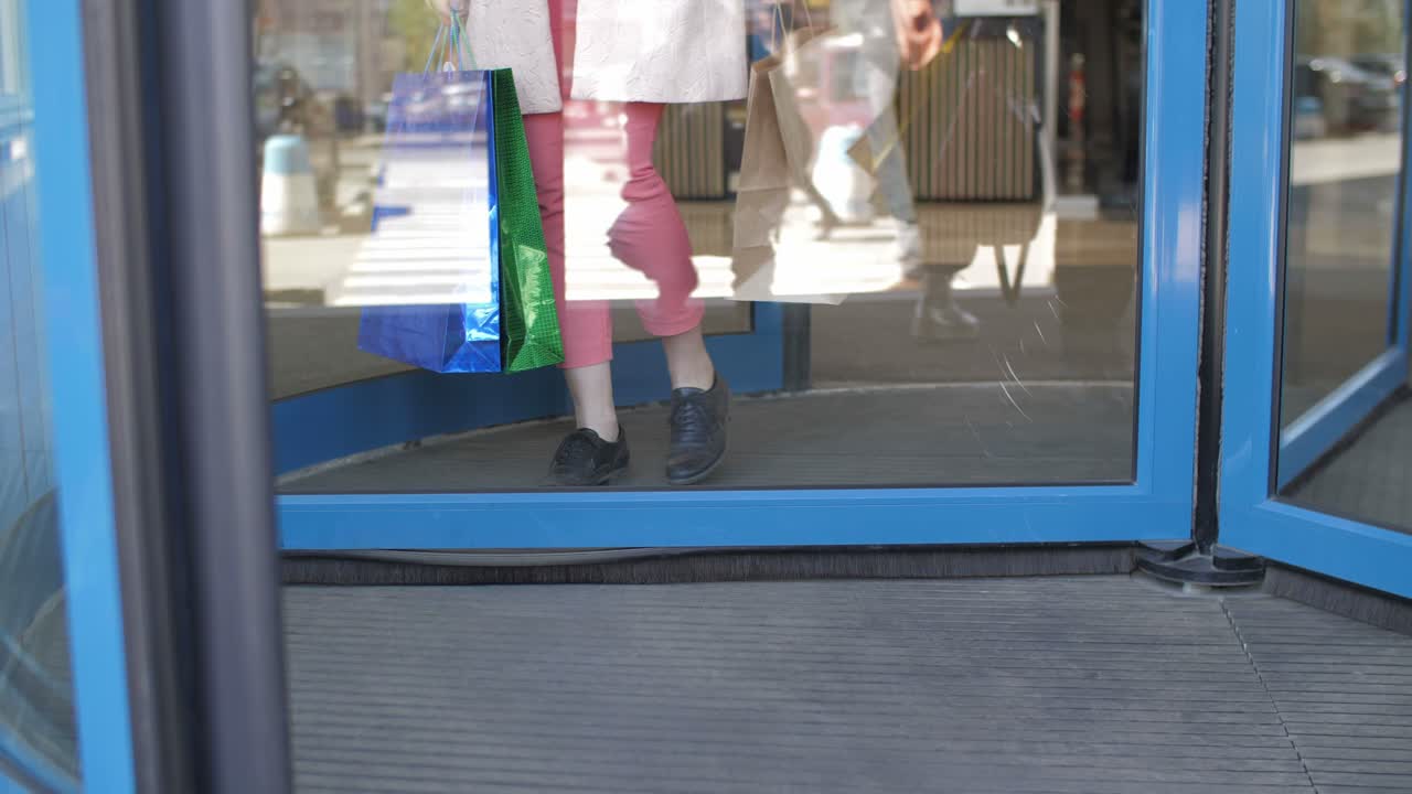 Woman exiting a store with shopping bags