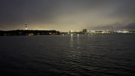 Reisen-Mit-Dem-Boot-In-Der-Nacht-Mit-Stadt--Und-Fabriklichtern-Am-Horizont