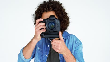 fotógrafo mostrando una tarjeta de visita mientras toma una foto con una cámara digital