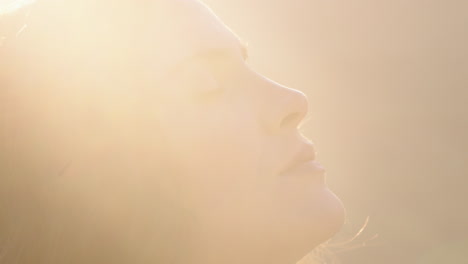 close up portrait of beautiful woman enjoying peaceful sunset exploring spirituality looking up praying contemplating journey with wind blowing hair