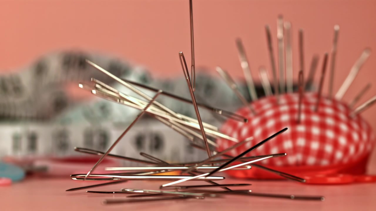 Sewing Needles Falling in Slow Motion with Craft Supplies