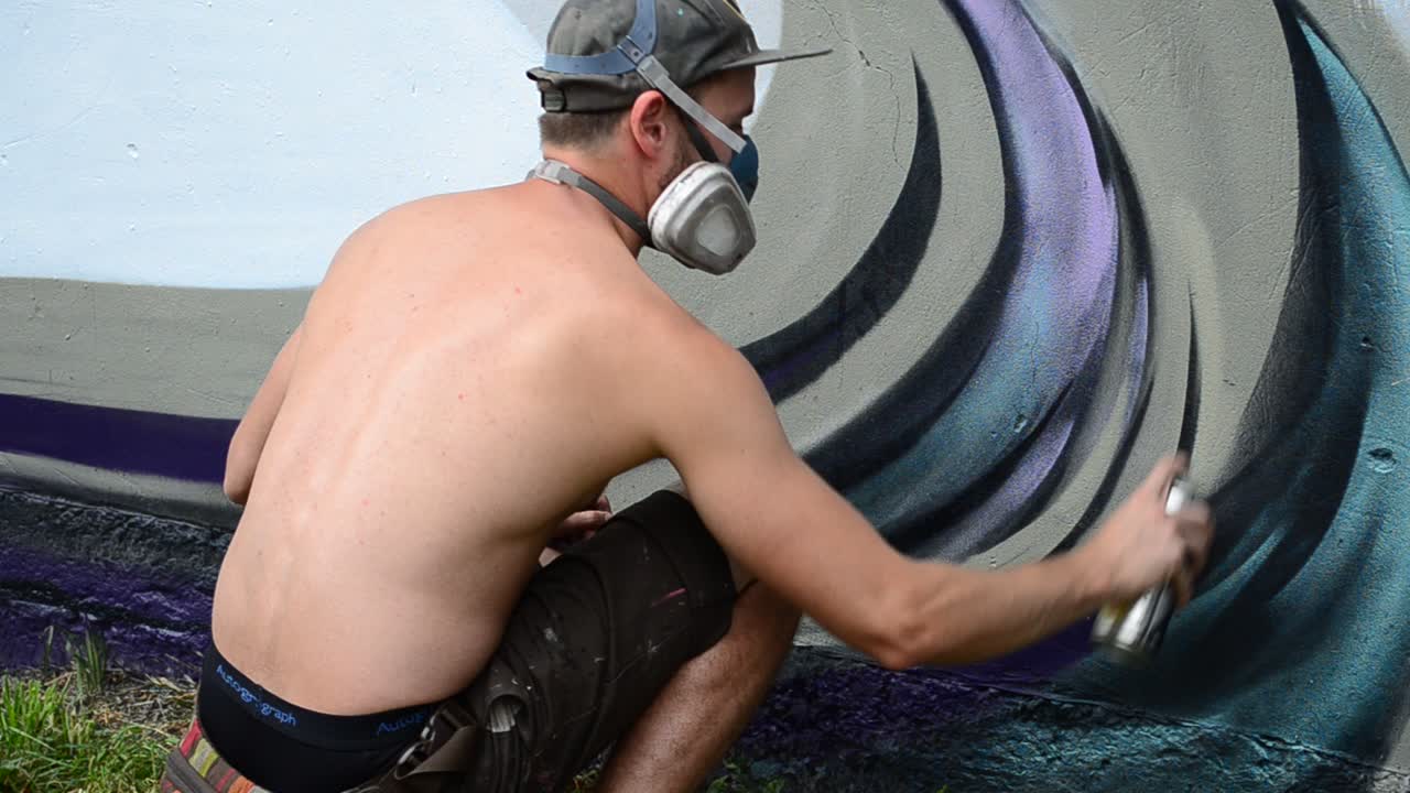 Process of creation of graffiti, fence. The artist draws graffiti