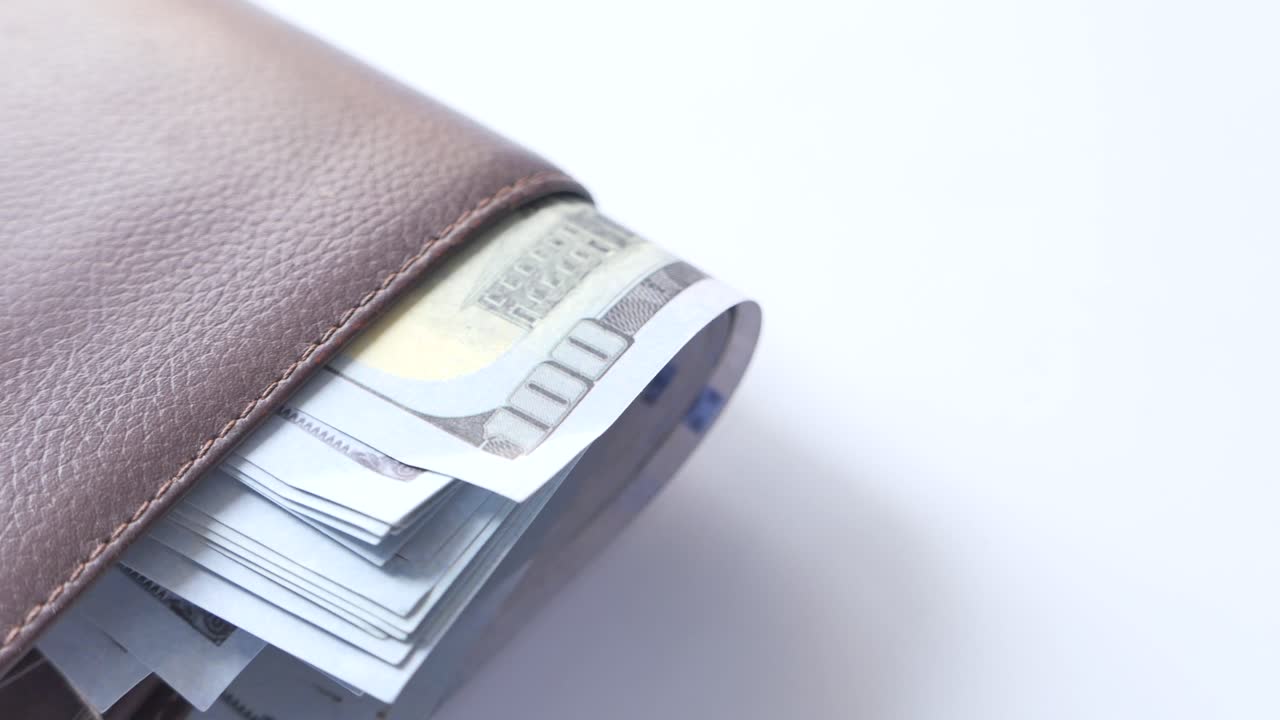 Close-up of a Brown Leather Wallet Filled with US Dollar Bills