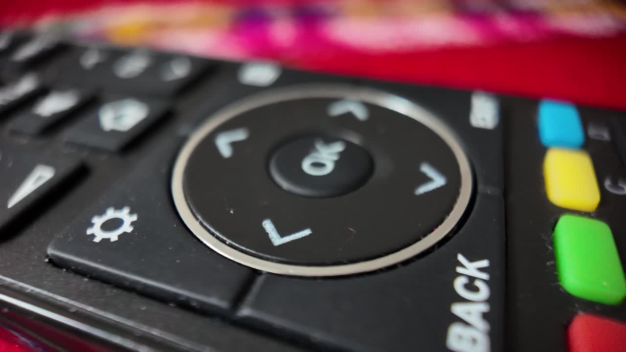 Modern remote control with colorful buttons for controlling a television, offering convenient access to various functions