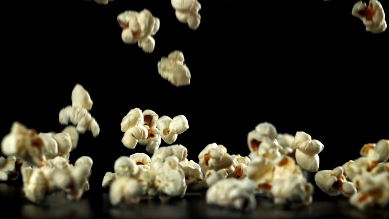 Popcorn che cadono al rallentatore su sfondo nero