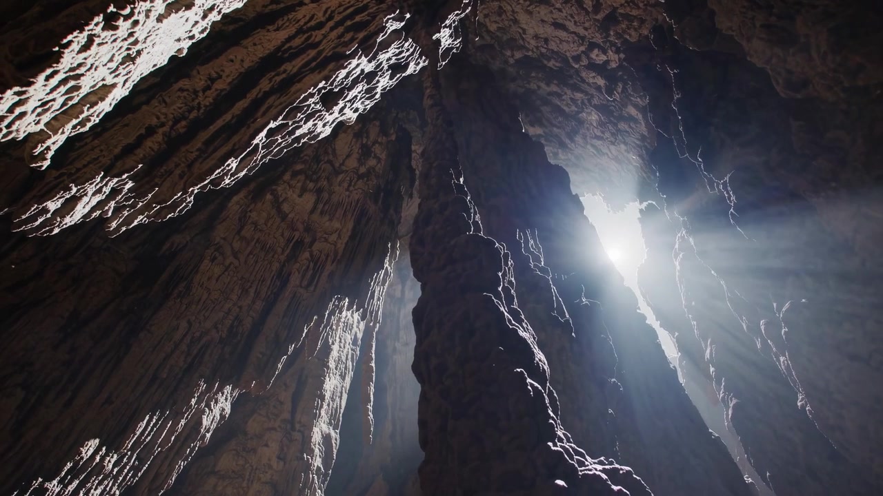 Sunlight Streaming Through Opening in Dark Cave Ceiling