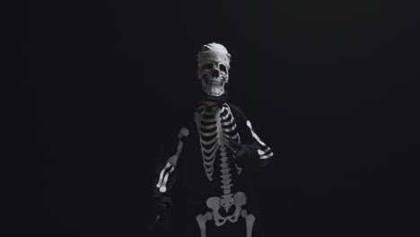 Studio-Shot-Of-Child-Dressed-Up-In-Skeleton-Costume-Trick-Or-Treating-At-Halloween-Dancing-Against-Black-Background-6