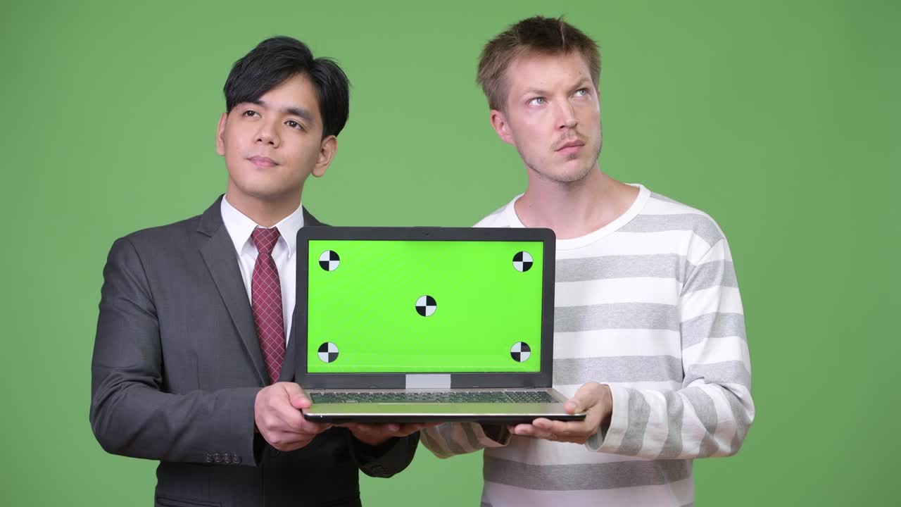 젊은 잘생긴 아시아 사업가와 젊은 스칸디나비아 사업가가 함께 일하고 있습니다.