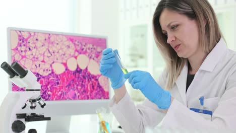 Scientist in Laboratory Examining Test Tube