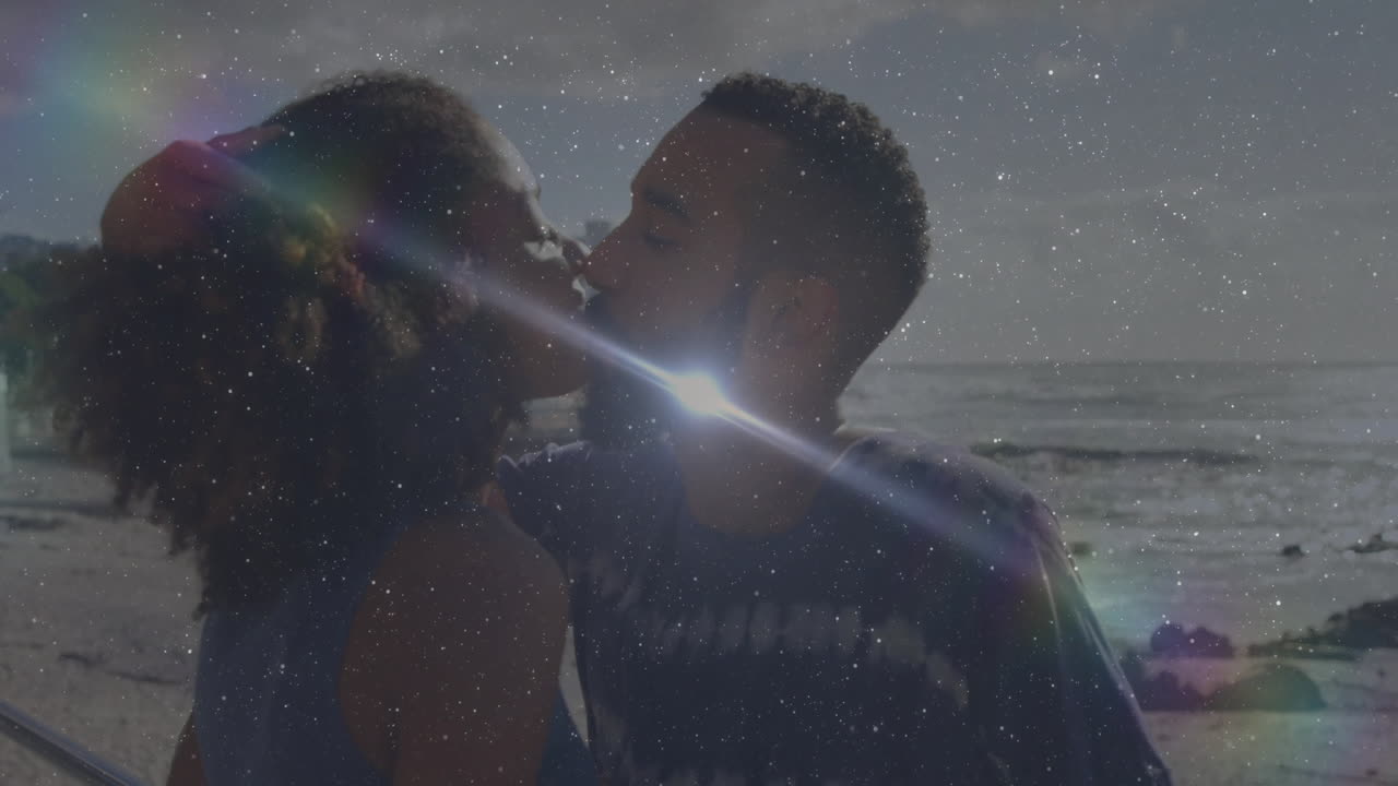 Kissing on beach, couple surrounded by sparkling light effects like animation