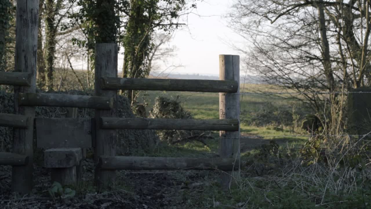 Countryside stile in English countryside, farmland wide panning shot