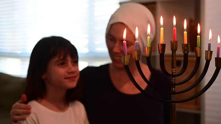 Jewish mother and daughter looking at a beautiful menorah on Hanukkah Jewish holiday