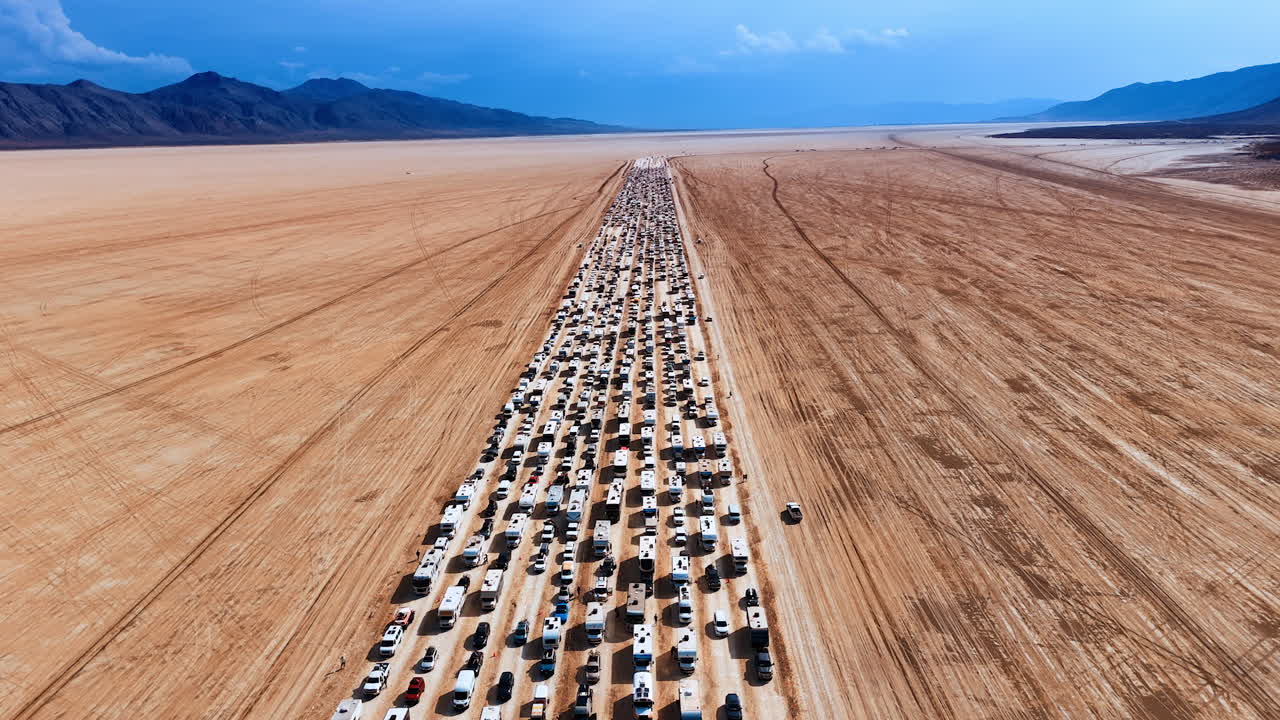 Endless Line of Cars and RVs on Arid Desert Playa