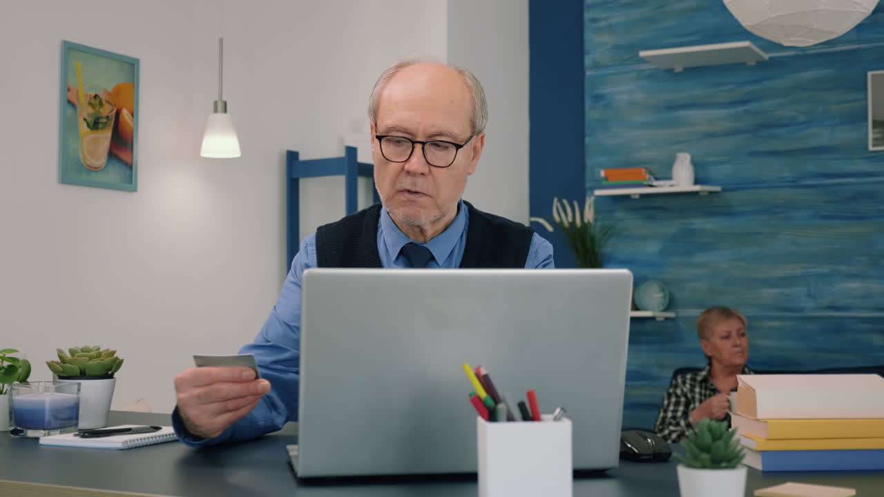 Retired man making shopping online doing payment using credit card on laptop