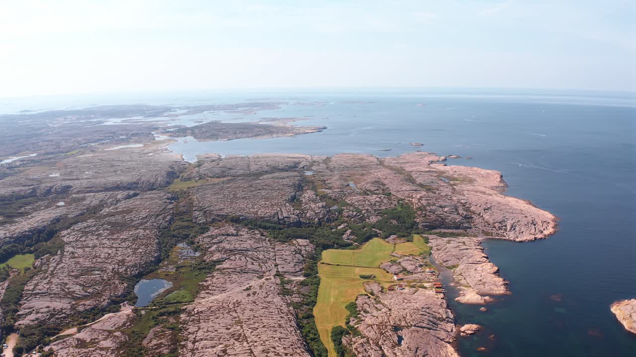 Rugged norwegian landscape with rocky shores and green fields, aerial view