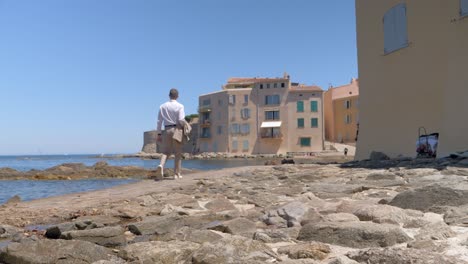 Slowmotion-shot-of-a-well-dressed-man-walking-alongside-the-ocean