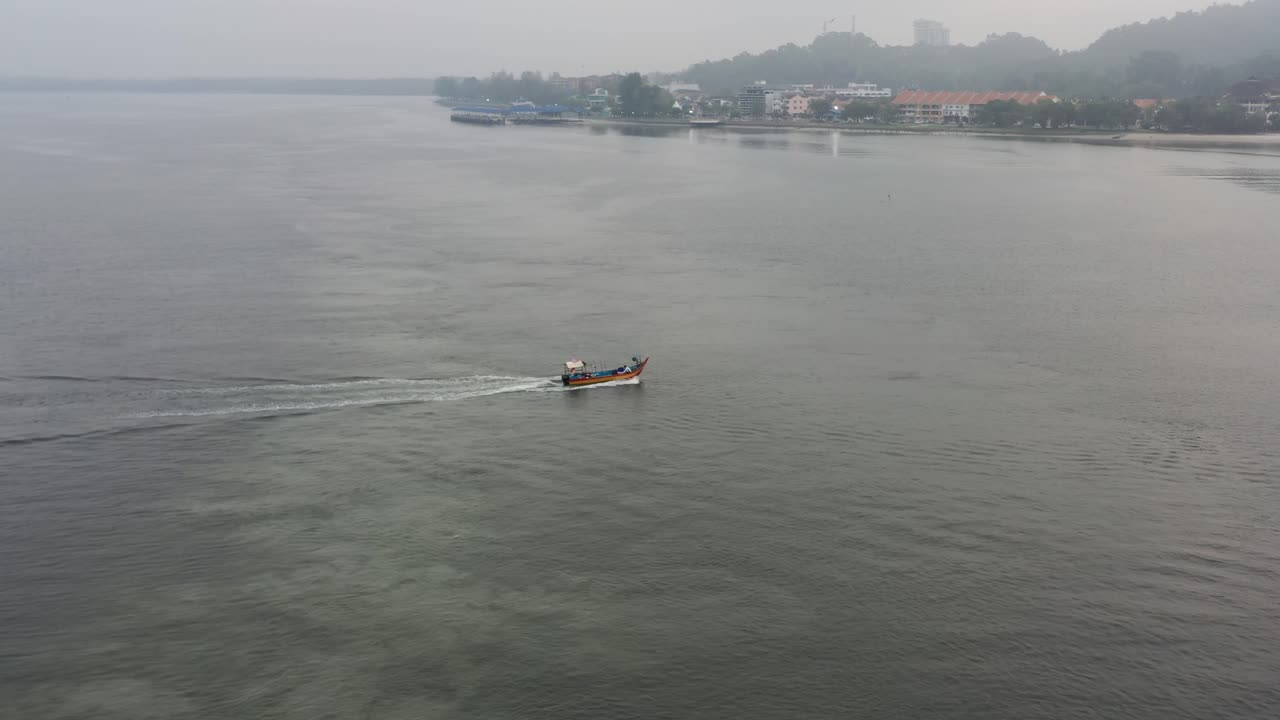 Drone fly around and flyover a traditional fishing boat sailing on the sea out for a morning catch at lumut, manjung, malaysia, southeast asia, fishery industry shot.