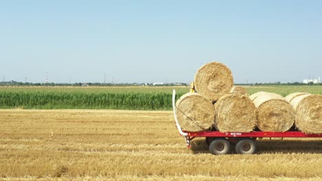 above view of agricultural field, collecting round bales of straw