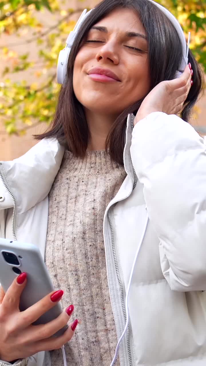 Woman enjoying music with headphones outdoors