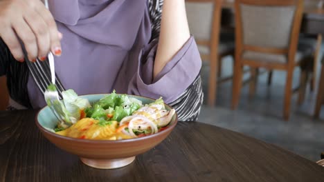 woman eating salad in a restaurant