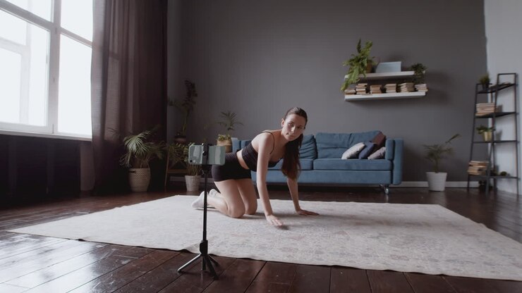 Inquadratura ampia di una giovane influencer che configura il suo smartphone prima della sua lezione di fitness online.