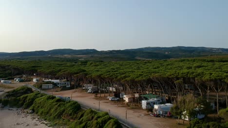 campsite-with-campers-in-Italy,-Sardaigne-enjoying-the-summer---aerial-shot